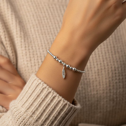 Model wearing a Feather charm women's 925 sterling silver stacking bracelet by My Silver Wish