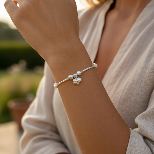 Model wearing a Puff heart charm sterling silver hand-made girl's stacking bracelet by My Silver Wish