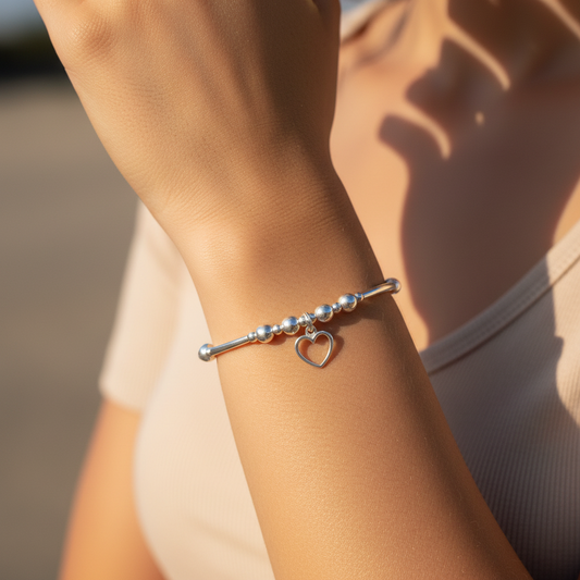Model wearing a Delicate open heart charm sterling silver hand-made stacking bracelet for her by My Silver Wish