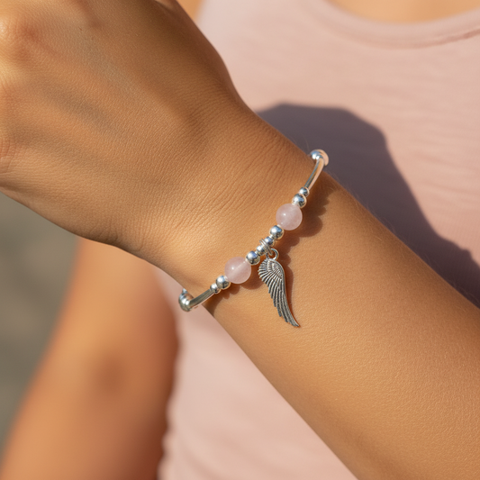 Model wearing a Angel wing charm & rose quartz sterling silver stacking bracelet by My Silver Wish