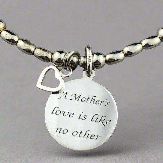 Closeup of "Mother's Love is Like No Other" sterling silver hand-made women's stacking charm bracelet by My Silver Wish