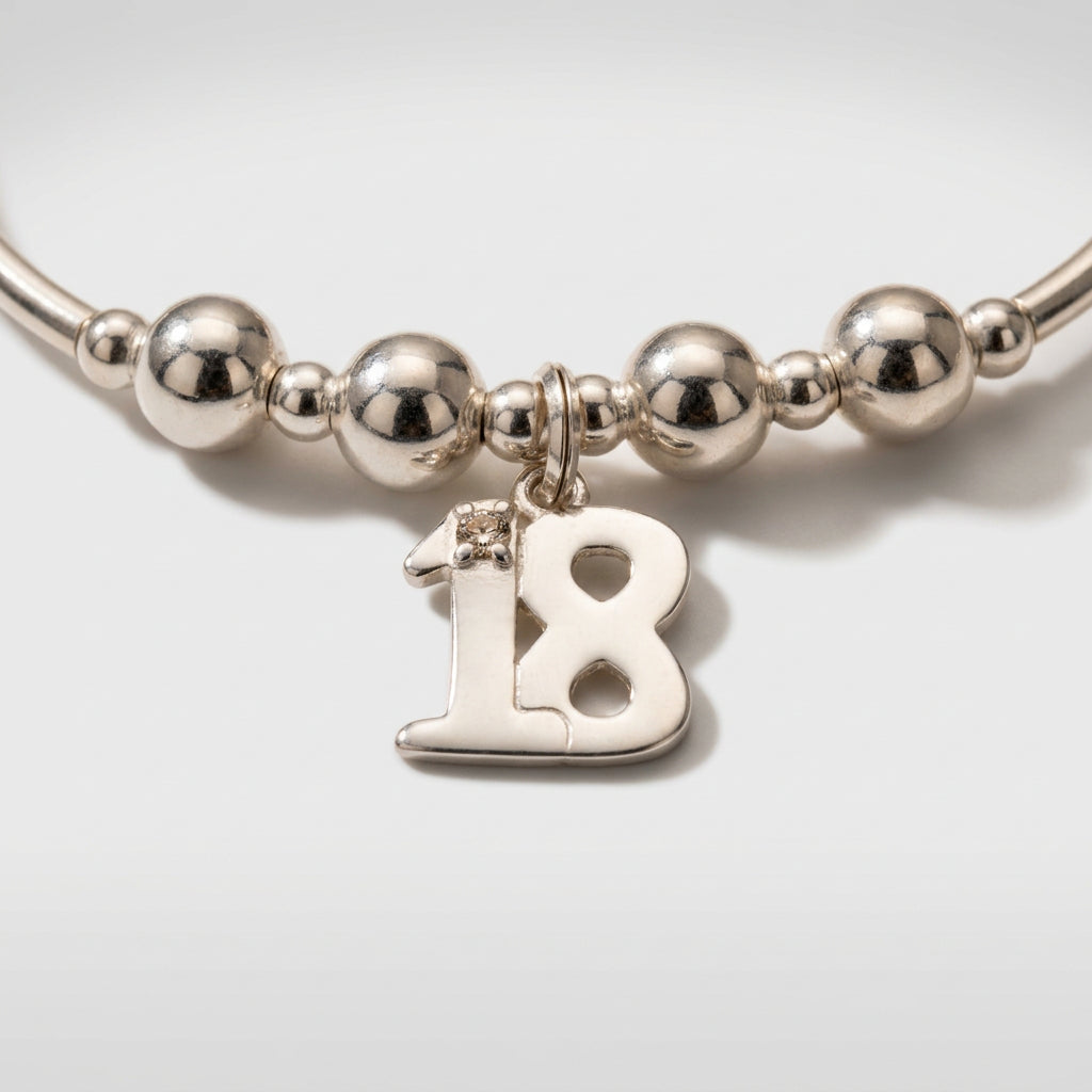 Closeup of 18th Birthday charm girl's sterling silver stacking bracelet by My Silver Wish