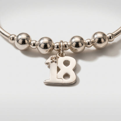 Closeup of 18th Birthday charm girl's sterling silver stacking bracelet by My Silver Wish