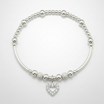 Silver bracelet with heart charm on a white background