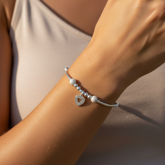 Model wearing a Diamond heart charm sterling silver hand-made women's stacking bracelet by My Silver Wish