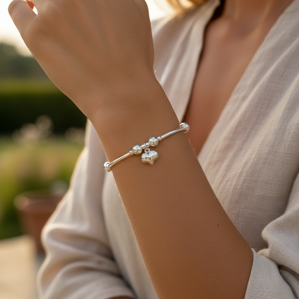 Model wearing a Puff heart charm sterling silver hand-made girl's stacking bracelet by My Silver Wish