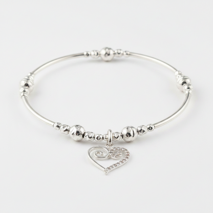 Silver bracelet with swirl heart charm on a white background