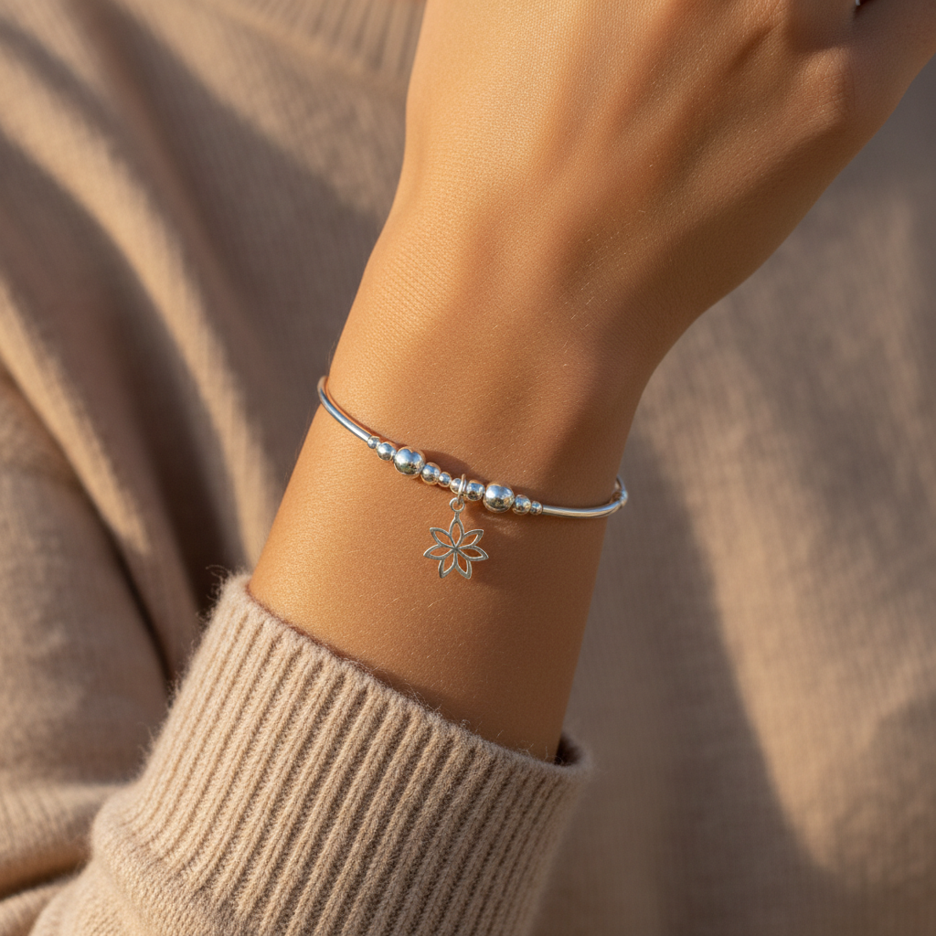 Model wearing a Flower charm sterling silver women's stacking bracelet by My Silver Wish