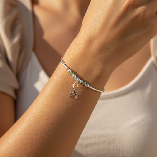 Model wearing a Mental Health Awareness ribbon charm sterling silver hand-made women's stacking bracelet by My Silver Wish
