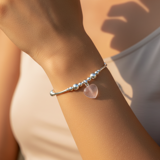 Model wearing a Rose quartz solid heart charm sterling silver hand-made women's stacking bracelet by My Silver Wish