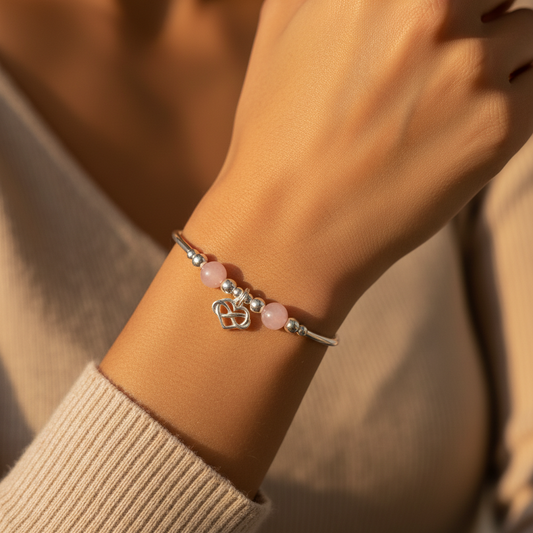 Woman wearing an Infinity heart charm rose quartz children's sterling silver stacking bracelet by My Silver Wish