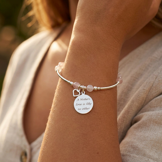 Model wearing a "Mother's Love is Like No Other" heart charm silver rose quartz women's stacking bracelet by My Silver Wish