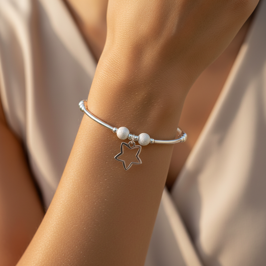 Model wearing a Open star charm sterling silver stacking bracelet for her by My Silver Wish