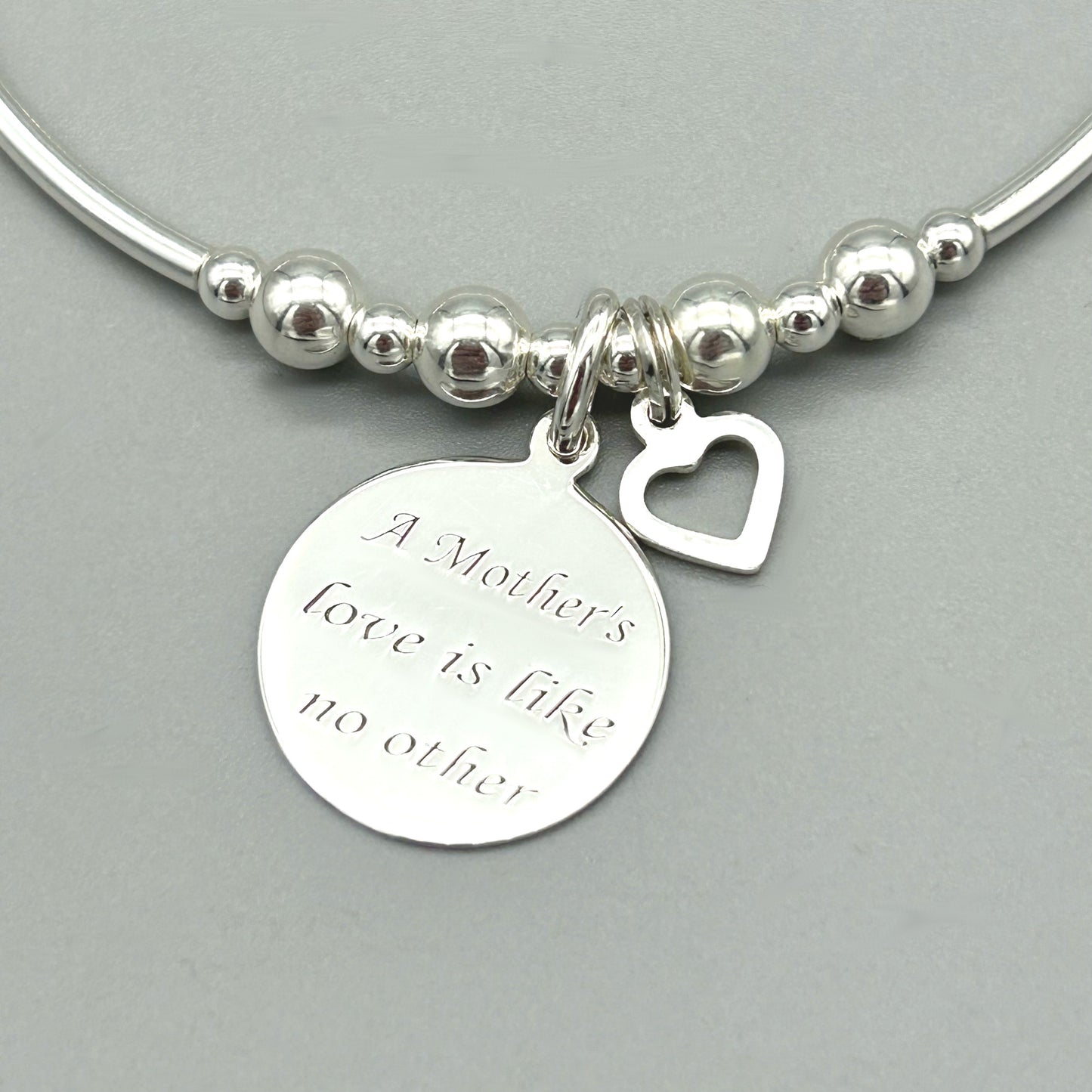 Closeup of "Mother's Love is Like No Other" & heart charm women's sterling silver stacking bracelet by My Silver Wish