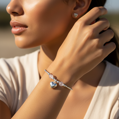 Model wearing a Puff heart charm sterling silver and Rose Quartz hand-made women's stacking bracelet and earring gift set by My Silver Wish