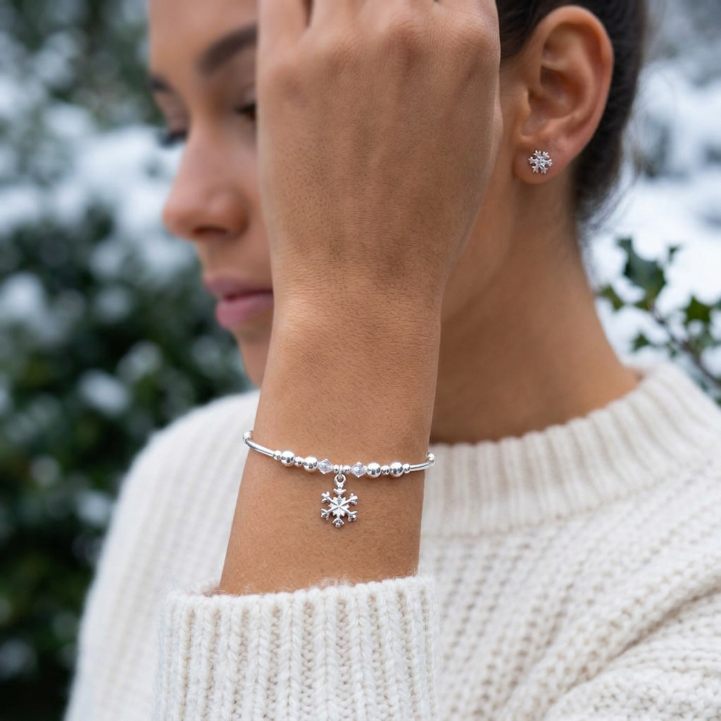 Model wearing a Snowflake charm sterling silver hand-made women's stacking bracelet and earring gift set by My Silver Wish