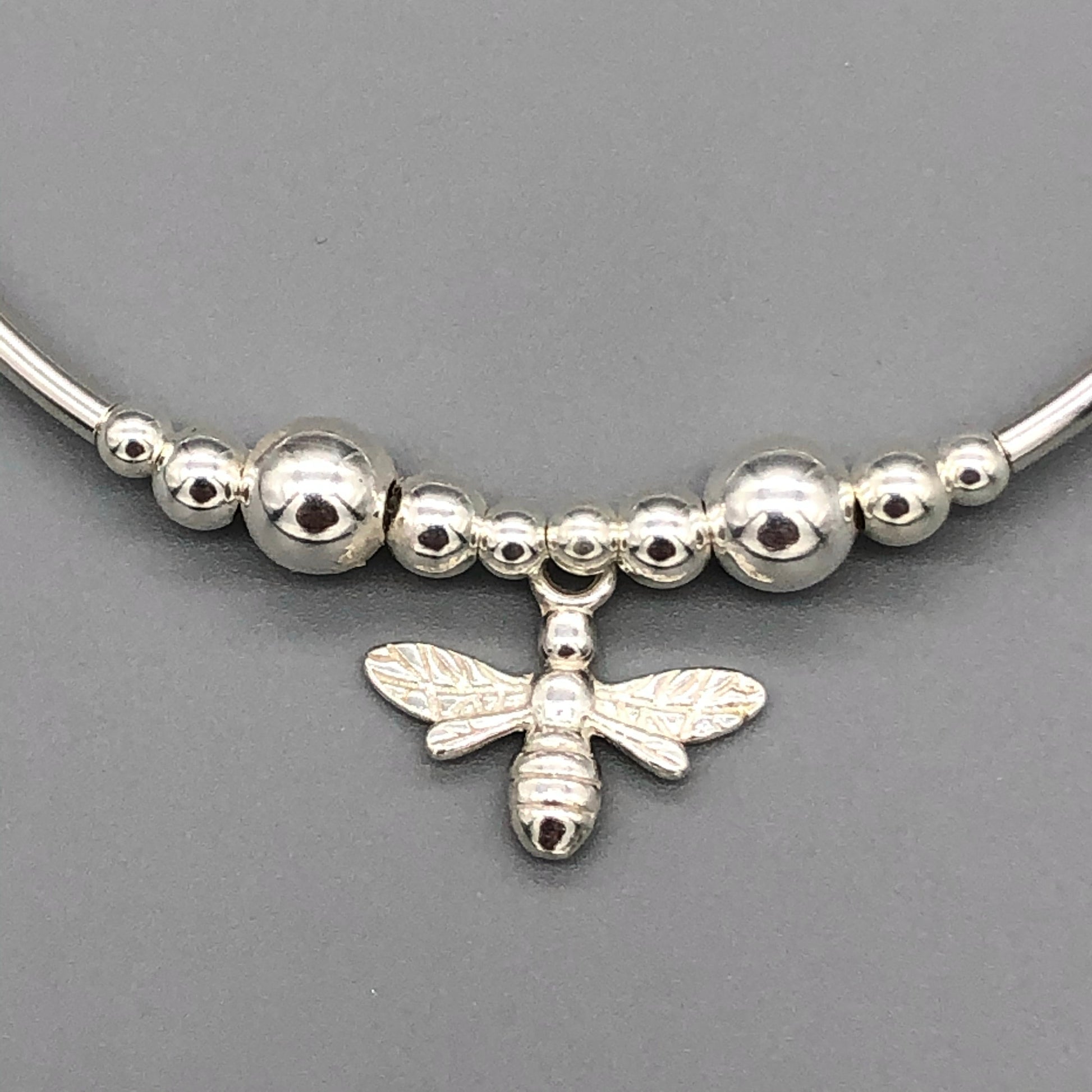 Closeup of bee charm women's sterling silver stacking stretch bracelet by My Silver Wish