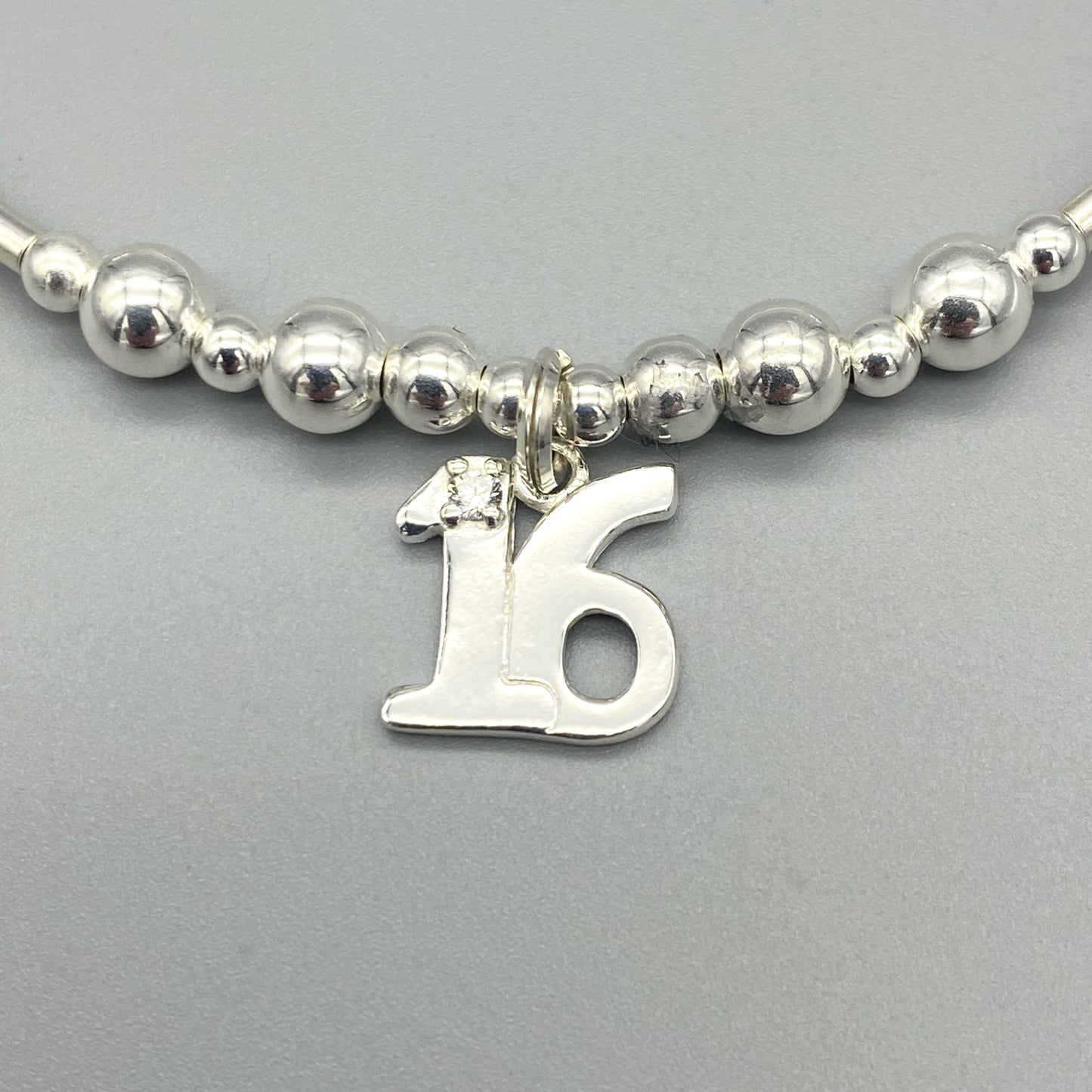 Closeup of 16th birthday charm sterling silver girl's stacking bracelet by My Silver Wish