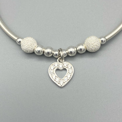 Closeup of Crystal heart sterling silver stacking charm bracelet by My Silver Wish