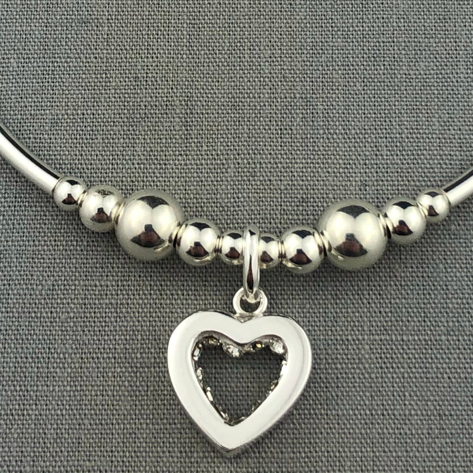 Closeup of Crystal heart charm sterling silver stacking charm bracelet by My Silver Wish