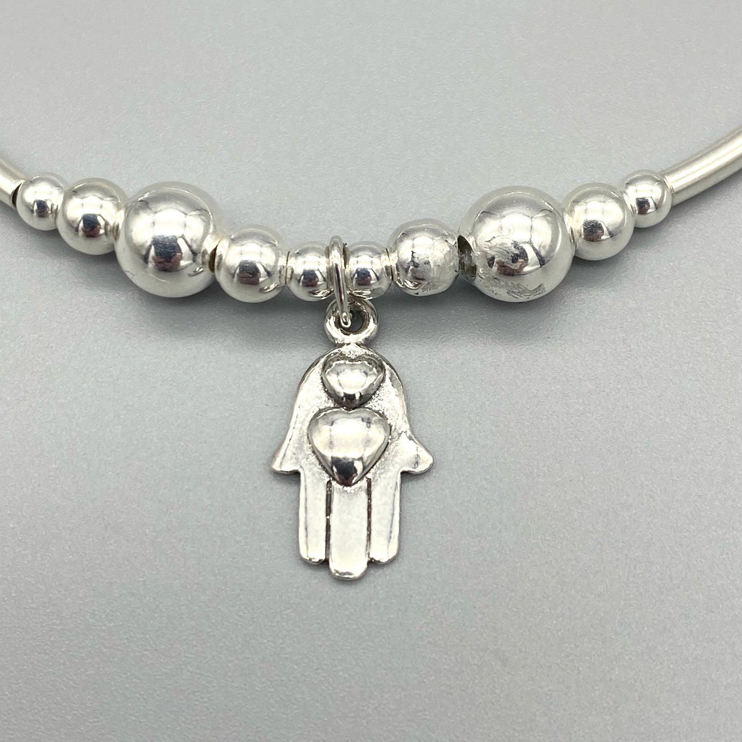 Closeup of Hamsa hand hearts charm sterling silver stacking bracelet for her by My Silver Wish