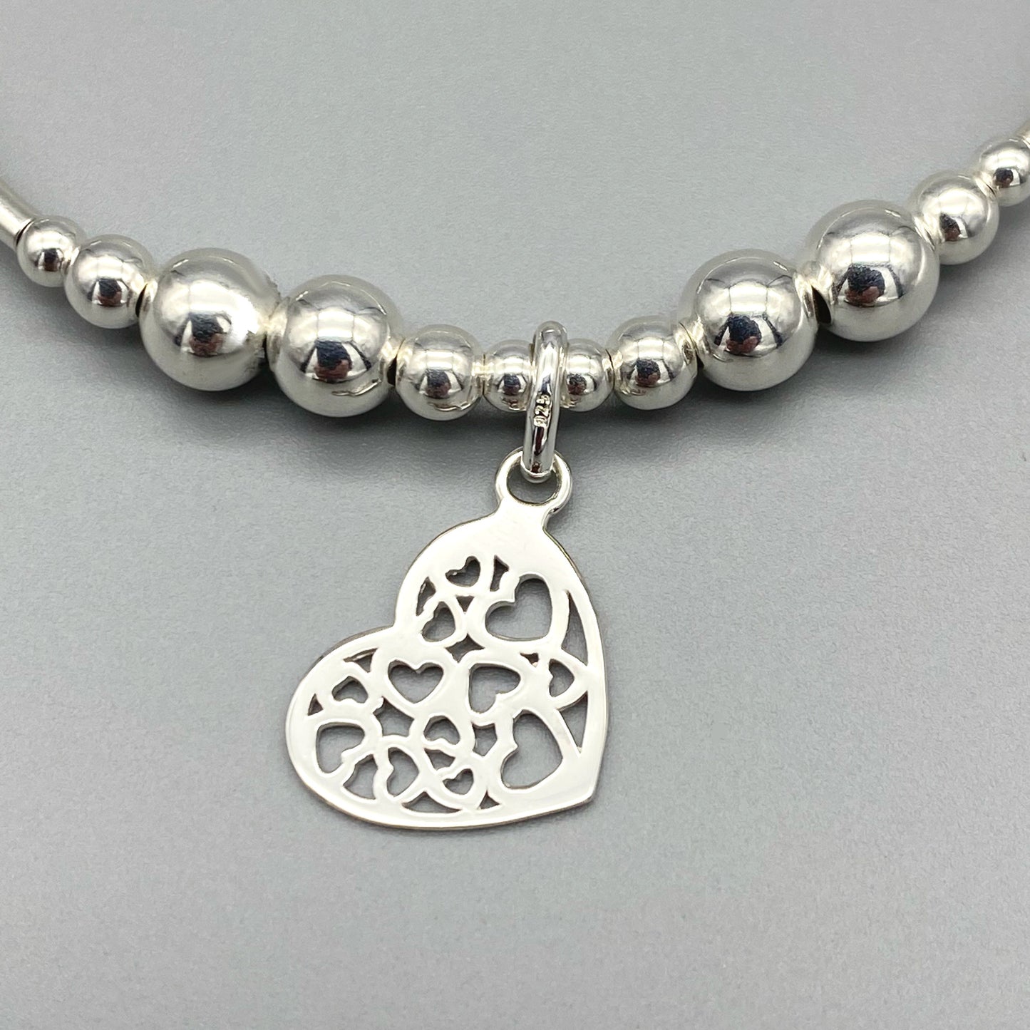 Closeup of Heart charm filigree sterling silver hand-made women's stacking bracelet by My Silver Wish