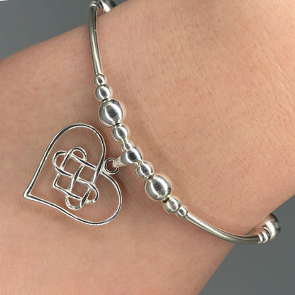 Closeup of Infinity charm heart women's sterling silver hand-made stacking bracelet by My Silver Wish