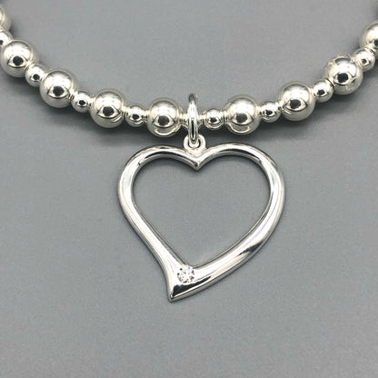 Closeup of Open heart charm women's sterling silver stacking bracelet by My Silver Wish