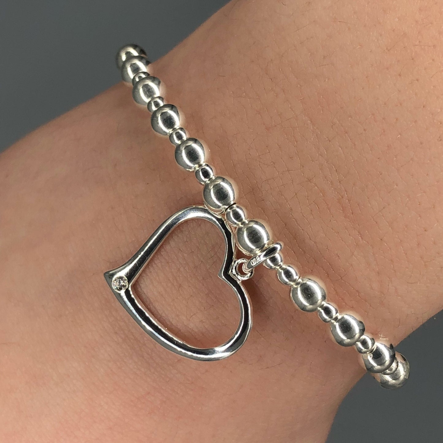 Closeup of Open heart charm women's sterling silver stacking bracelet by My Silver Wish