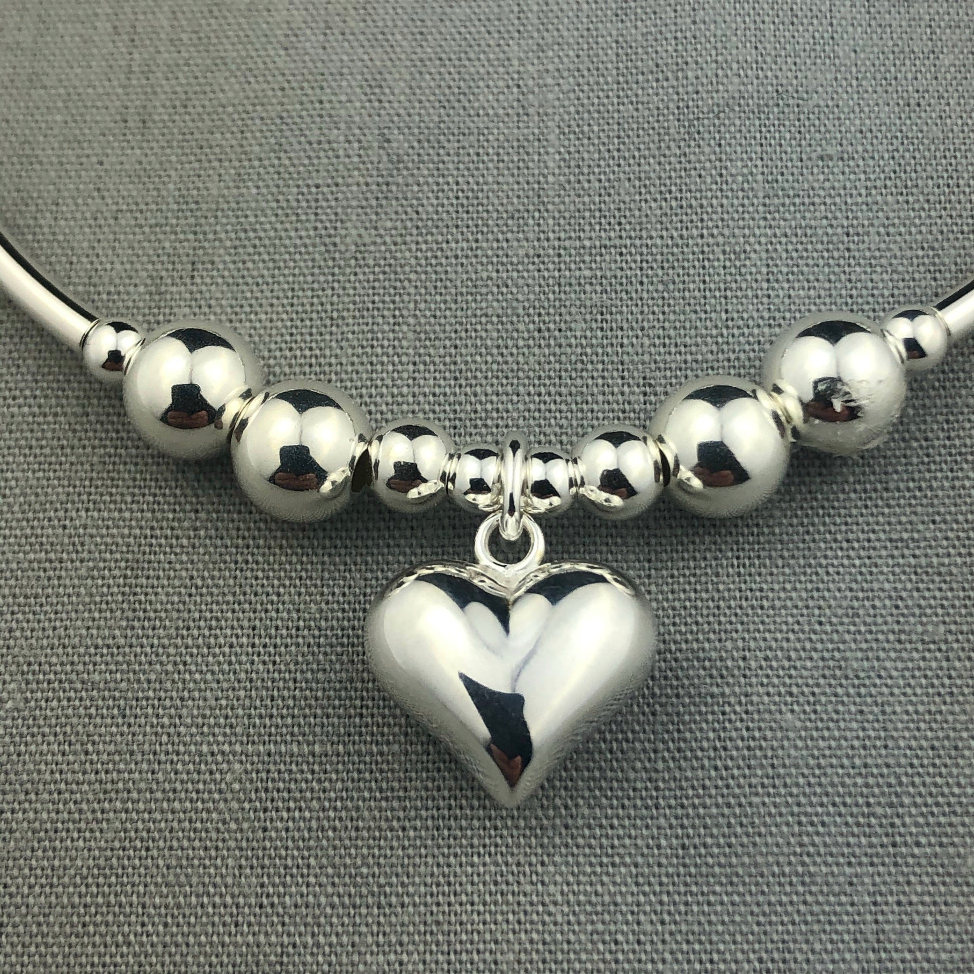 Closeup of Solid puff heart sterling silver stacking charm bracelet by My Silver Wish