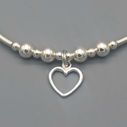 Closeup of Delicate open heart charm sterling silver hand-made women's stacking bracelet by My Silver Wish