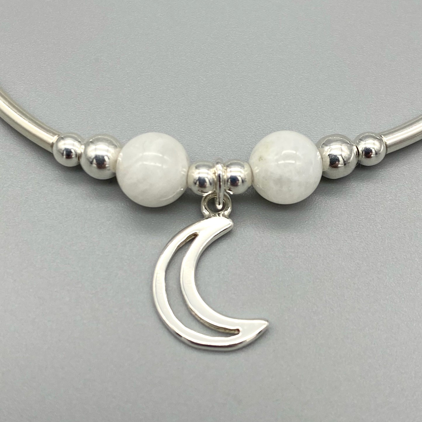 Closeup of Crescent Moon charm Moonstone healing crystal & sterling silver stack bracelet