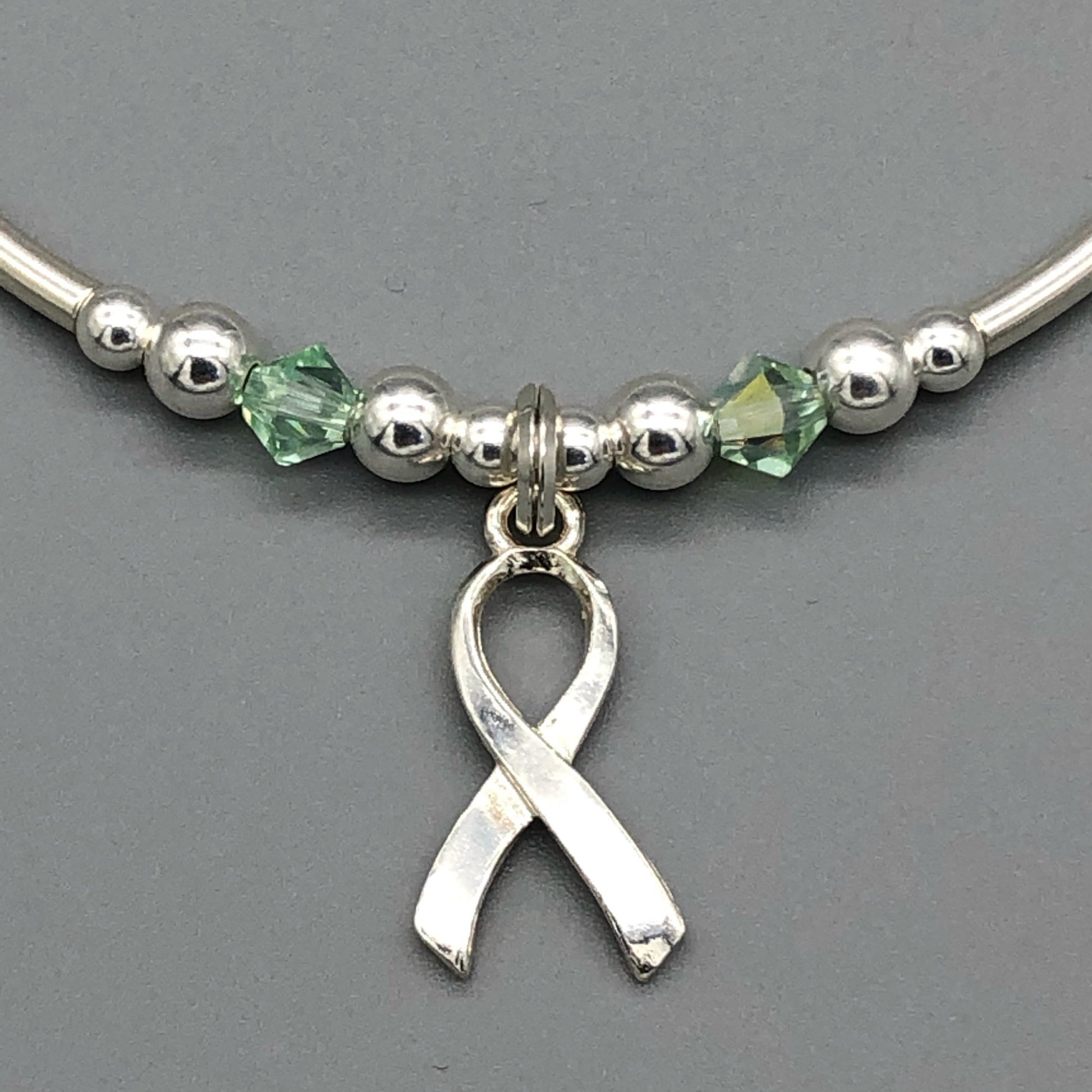 Closeup of Mental Health Awareness ribbon charm sterling silver hand-made women's stacking bracelet by My Silver Wish