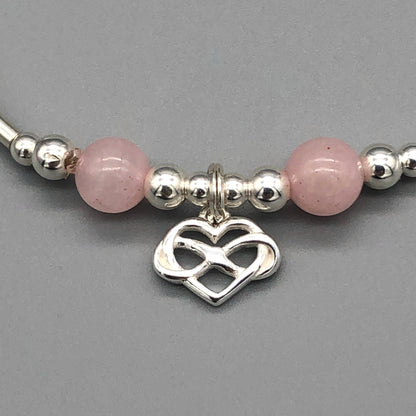 Closeup of Infinity heart rose quartz & sterling silver stacking charm bracelet by My Silver Wish