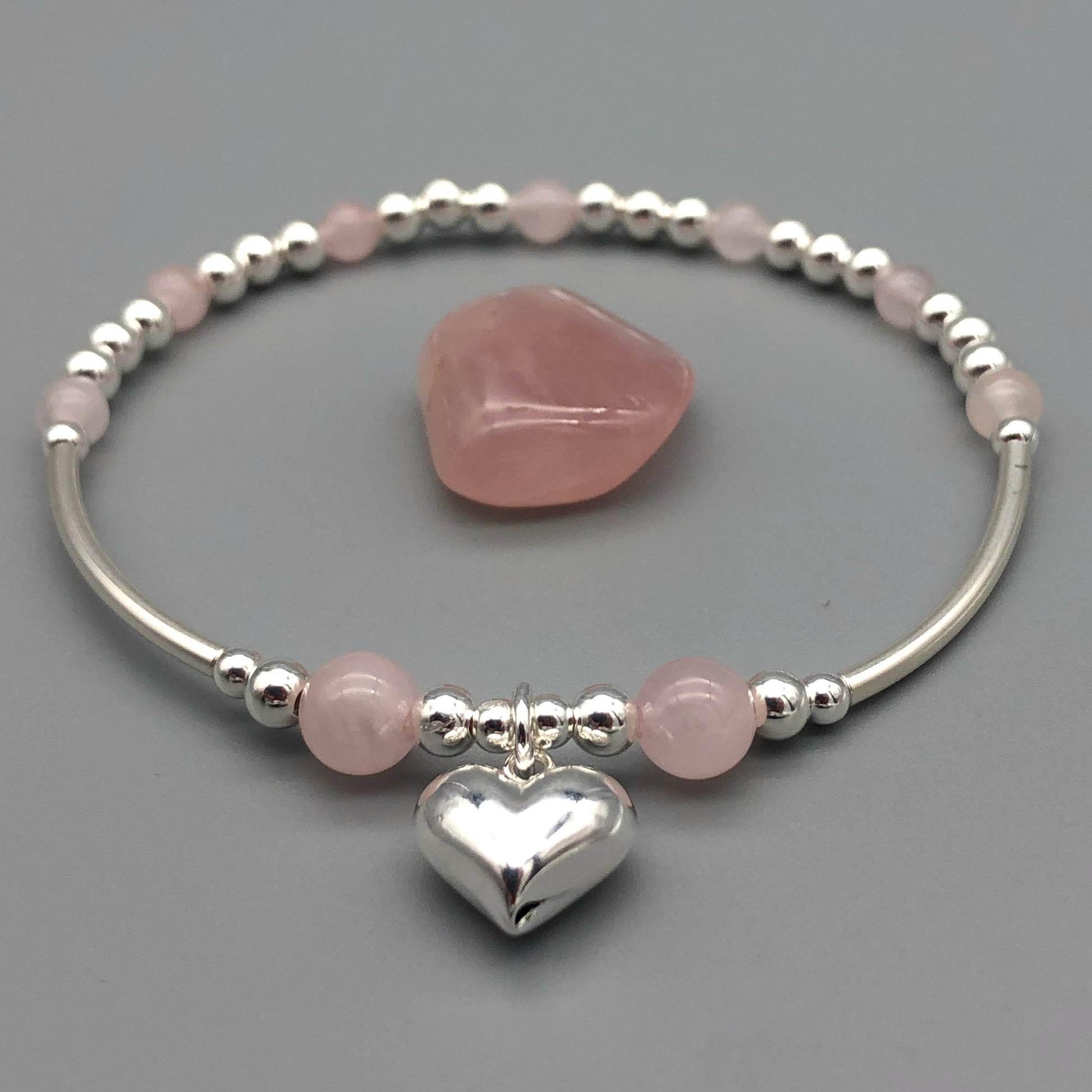 Clseup of Rose quartz puff heart charm sterling silver women's stacking bracelet by My Silver Wish