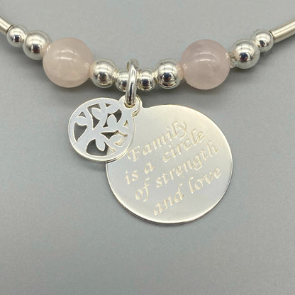 Closeup of "Family is a circle of strength & love" charm rose quartz women's sterling silver stacking bracelet by My Silver Wish