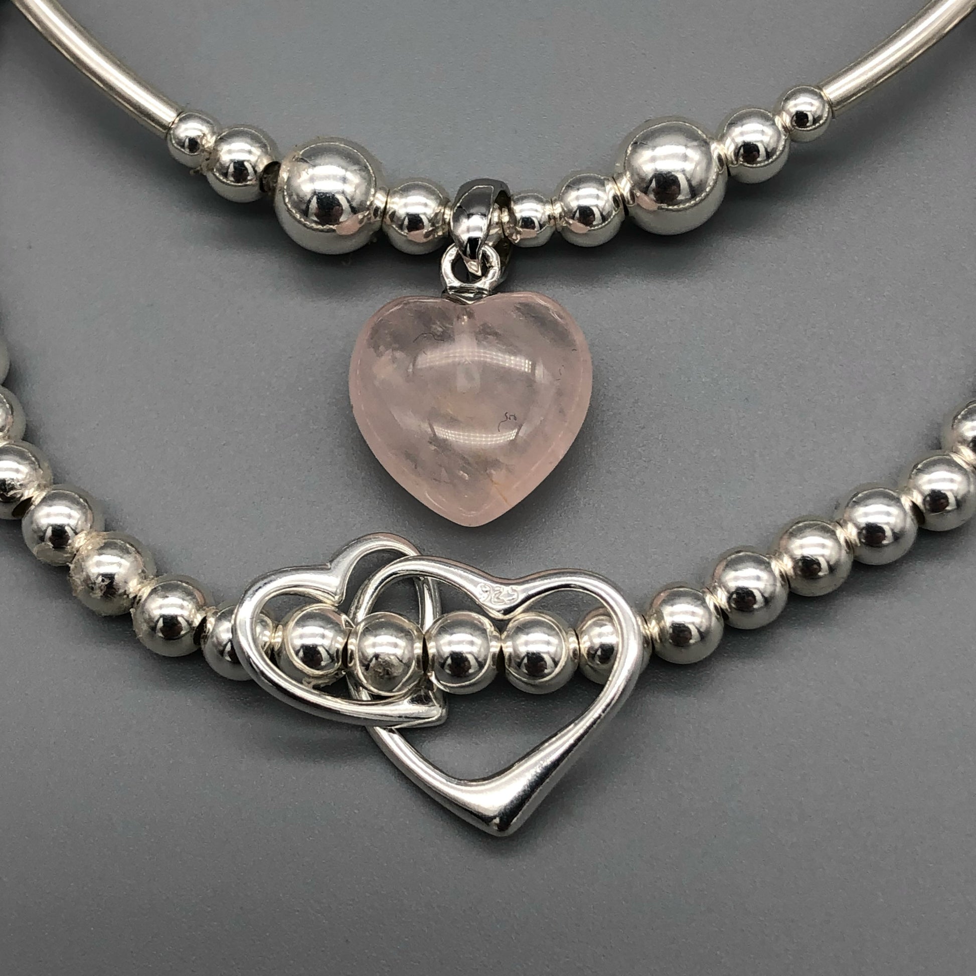 Closeup of Rose quartz heart & sterling silver twin heart charms women's stacking bracelet set by My Silver Wish