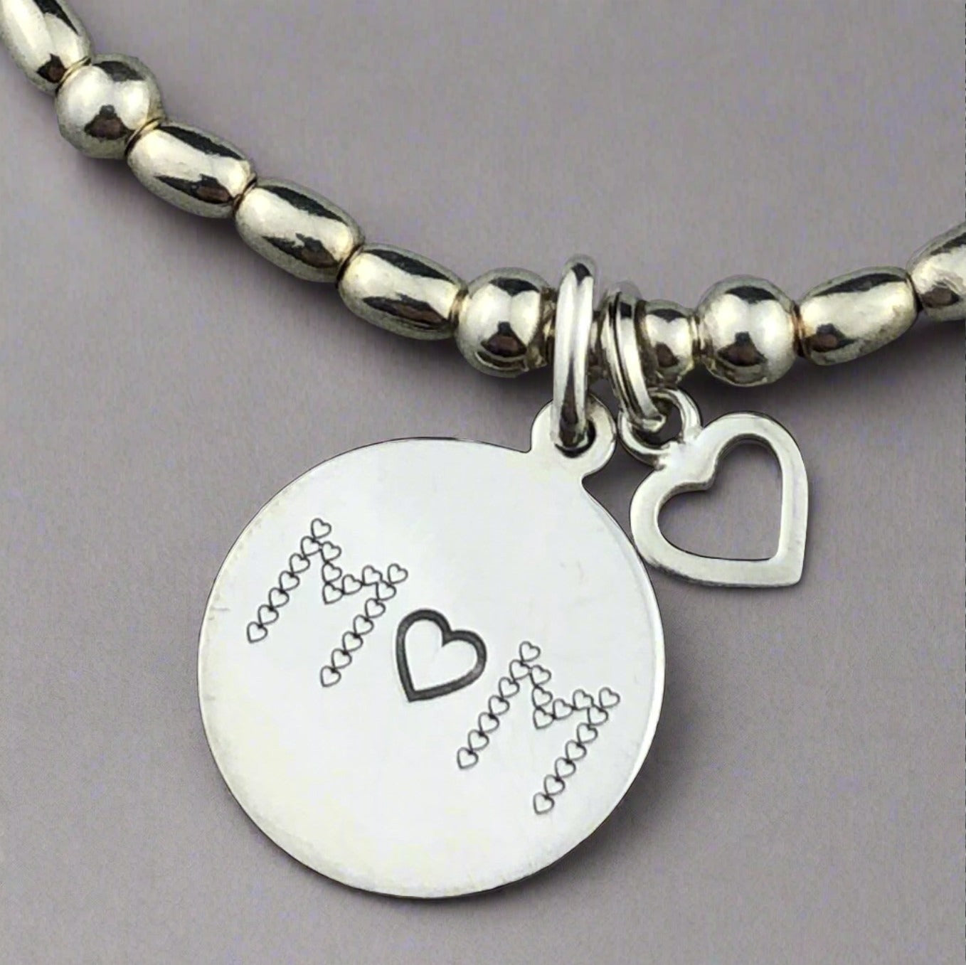 Closeup of "Mum" sterling silver hand-made women's stacking charm bracelet by My Silver Wish
