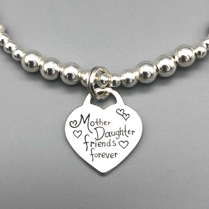 Closeup of "Mother & Daughter Friends Forever" heart charm silver women's stacking bracelet by My Silver Wish