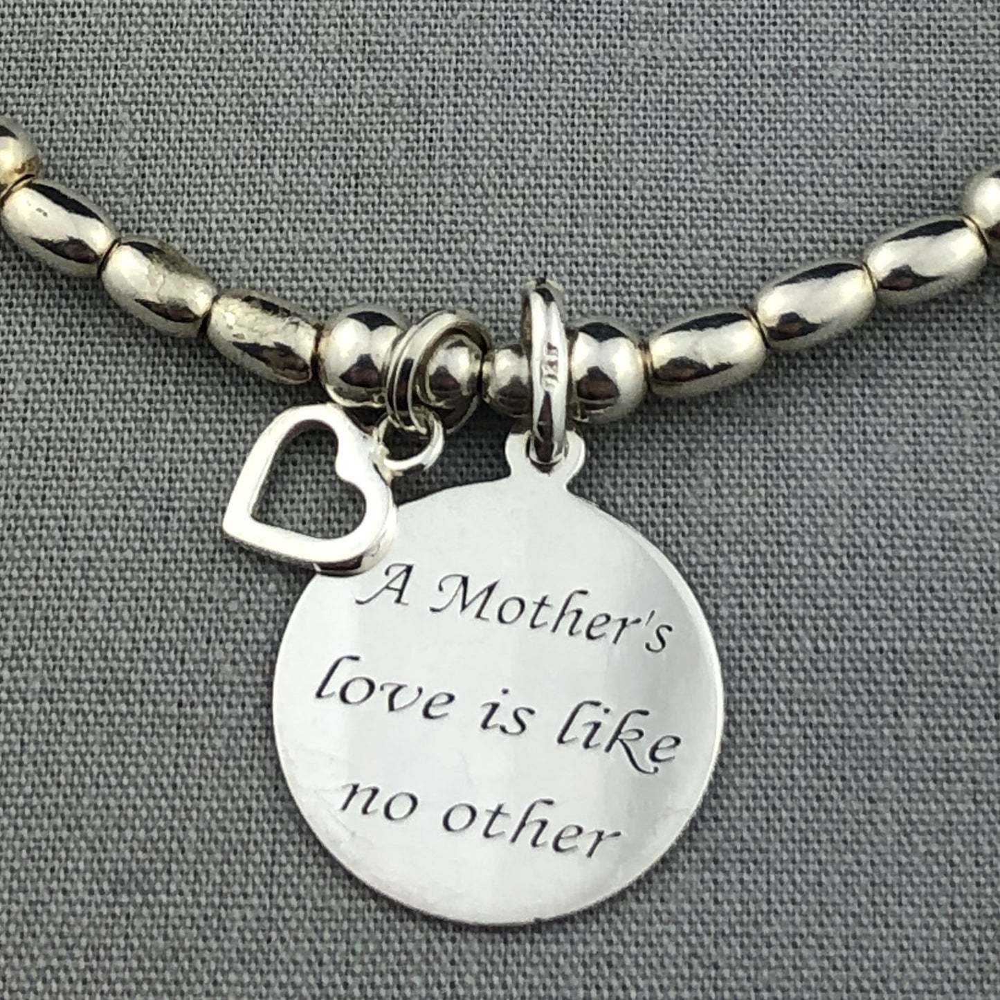 Closeup of "Mother's Love is Like No Other" sterling silver hand-made women's stacking charm bracelet by My Silver Wish