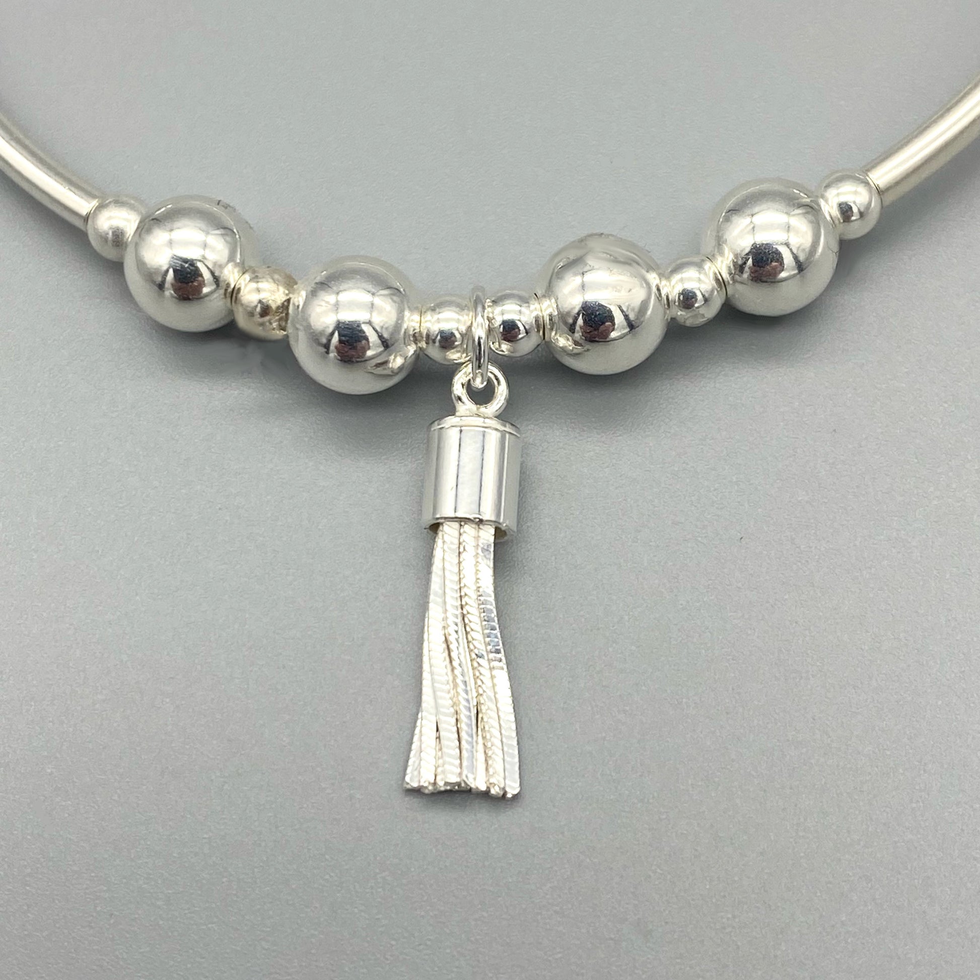 Closeup of Tassel charm sterling silver stacker bracelet by My Silver Wish