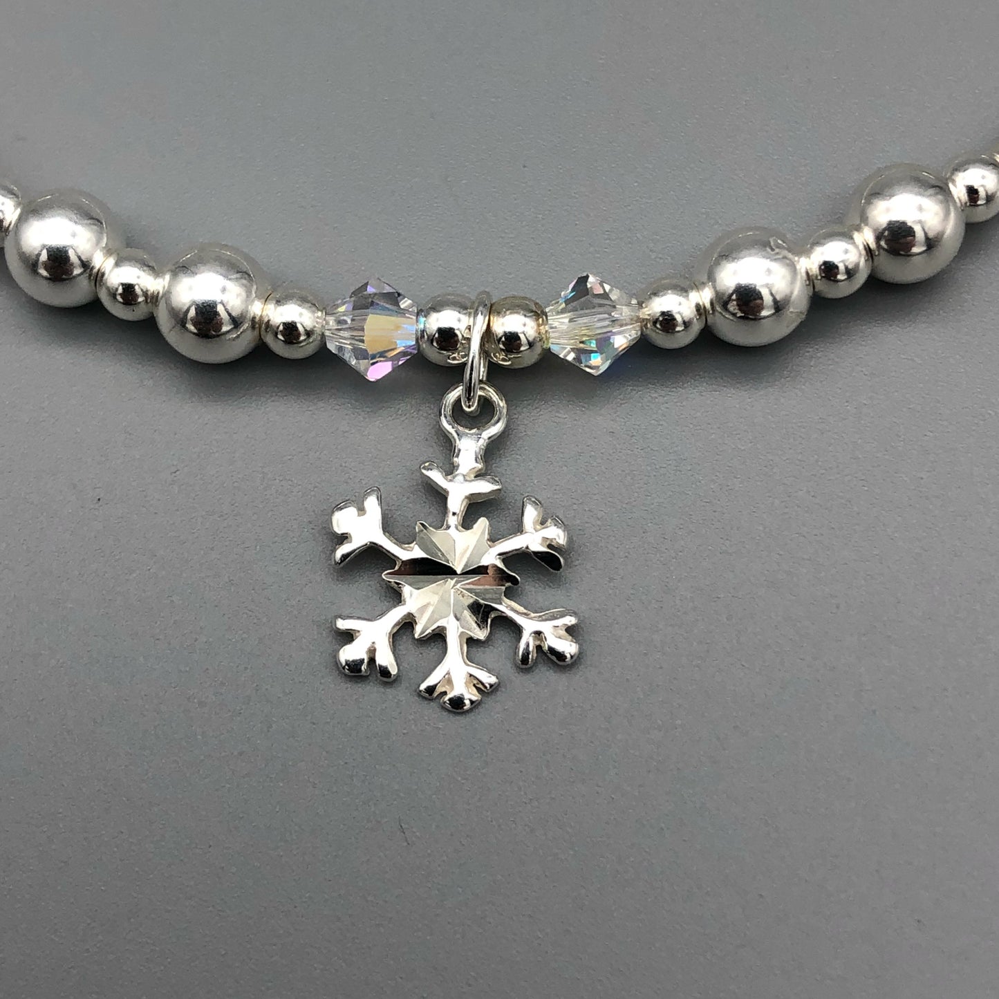 Closeup of Snowflake charm sterling silver hand-made women's stacking bracelet by My Silver Wish